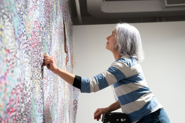 Elana Herzog installing her exhibition at Koffler Arts